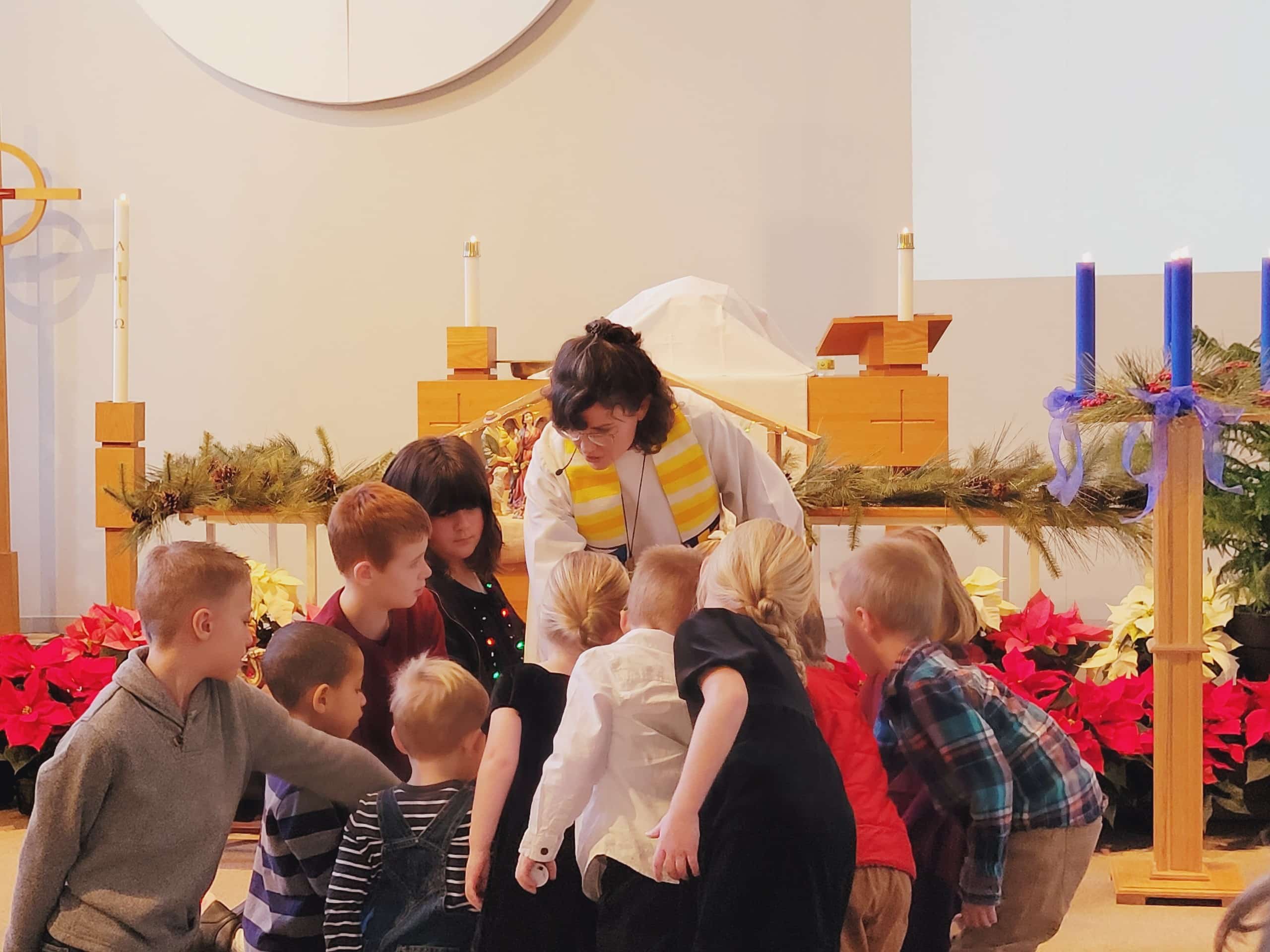 children gathered around a pastor at church